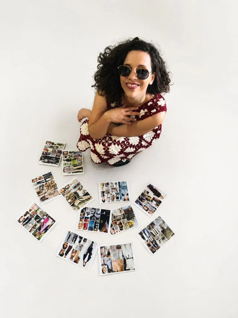 Filipa Longras de óculos de sol, sentada no chão, rodeada de imagens de referência de moda